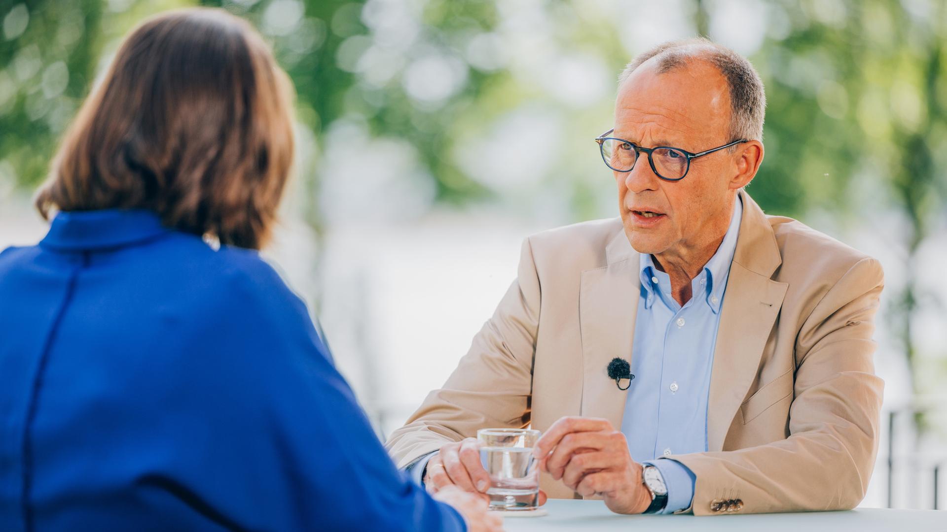Diana Zimmermann und Friedrich Merz sitzen sich gegenüber und sind im Gespräch.