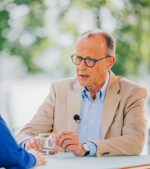 Diana Zimmermann und Friedrich Merz sitzen sich gegenüber und sind im Gespräch.