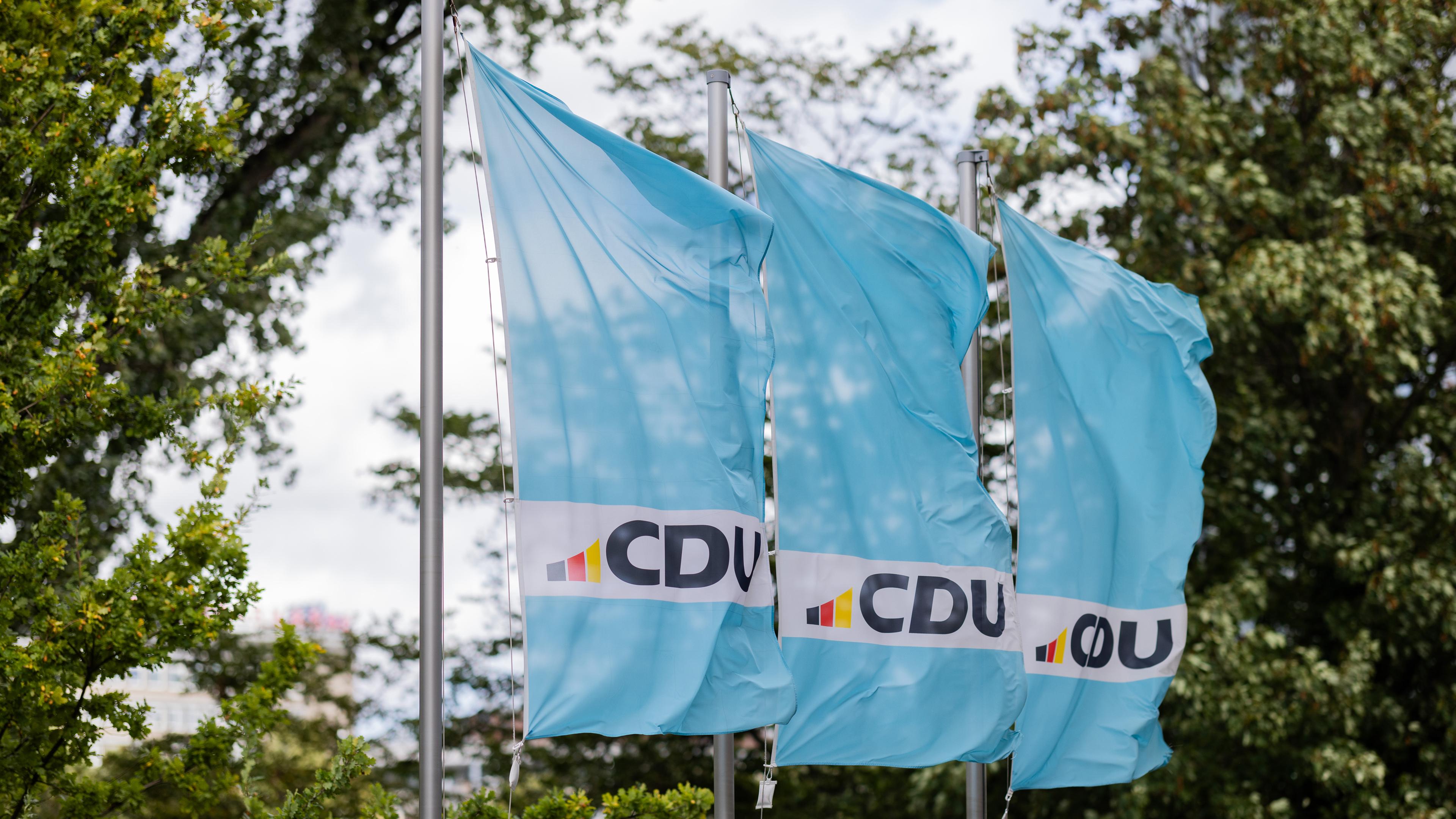 15.09.2025, Nordrhein-Westfalen, Düsseldorf: Flaggen mit dem Logo der CDU wehen vor der Parteizentrale vor einem Statement zu den Kommunalwahlen.