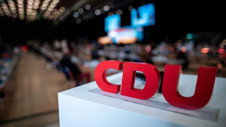 Das Logo der CDU steht auf einem kleinen Podest im Saal.