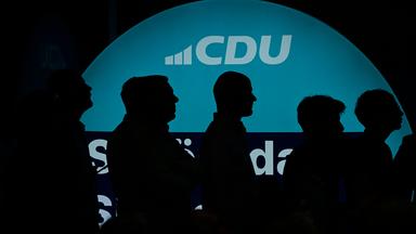 Supporters of Germany's conservative Christian Democratic Union (CDU) party are silhouetted against its logo during a campaign event at the party's headquarters in Berlin, on September 17, 2026. Berlin's State elections take place on September 20, 2026. 