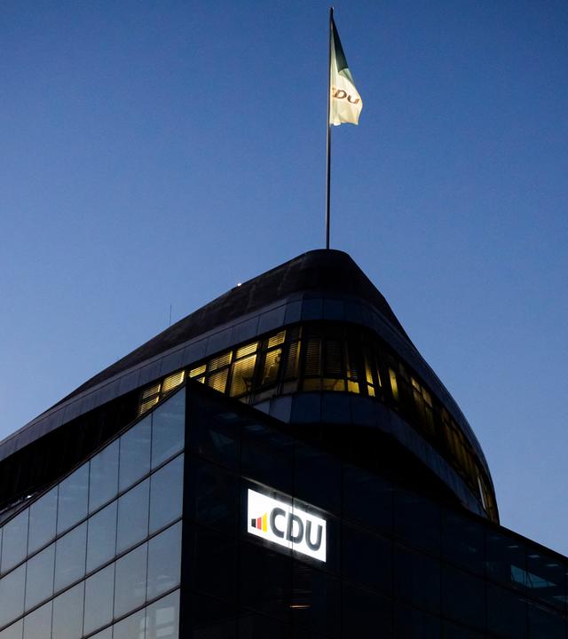 Eine CDU-Flagge weht auf dem Dach des Konrad-Adenauer-Hauses am Abend.