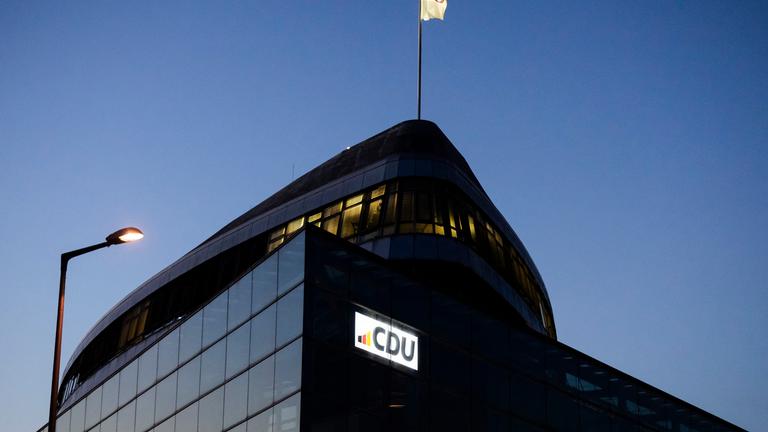 Eine CDU-Flagge weht auf dem Dach des Konrad-Adenauer-Hauses am Abend.