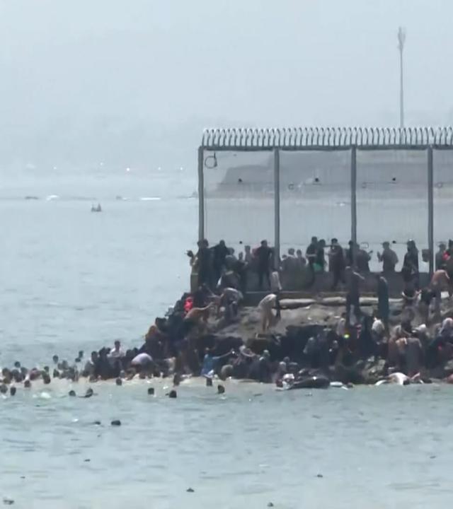 Menschen aus Marokko kommen an der Grenze zur spanischen Exklave Ceuta an.