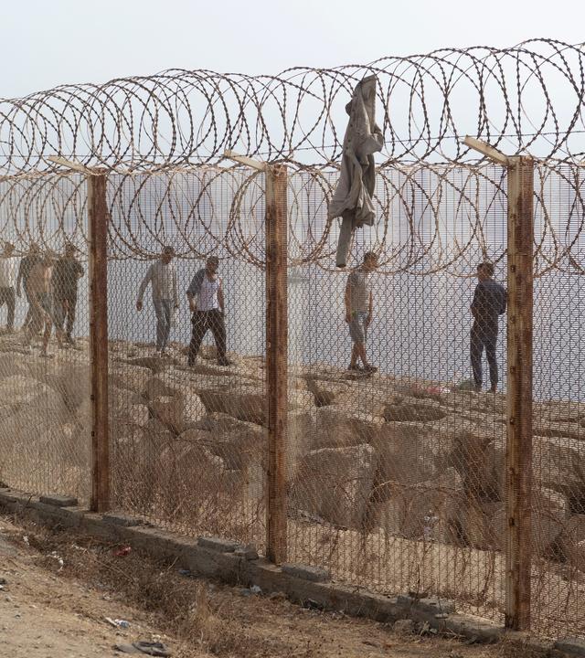 Menschen, die versucht hatten, nach Ceuta,Spanien, zu gelangen, kehren in die marokkanische Stadt Fnideq im Norden zurück. 