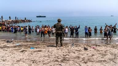 Menschen am Strand von Ceuta, die von Marokko in die spanische Enklave kommen.