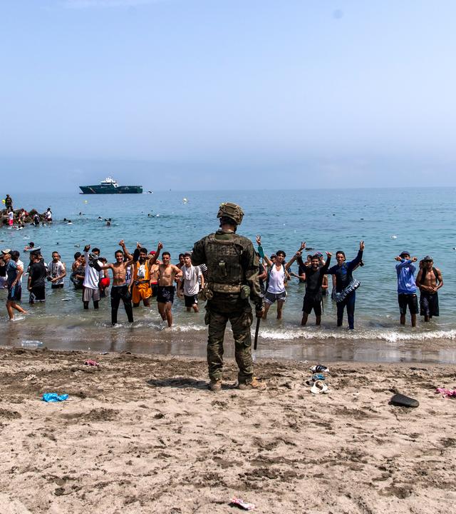 Menschen am Strand von Ceuta, die von Marokko in die spanische Enklave kommen.