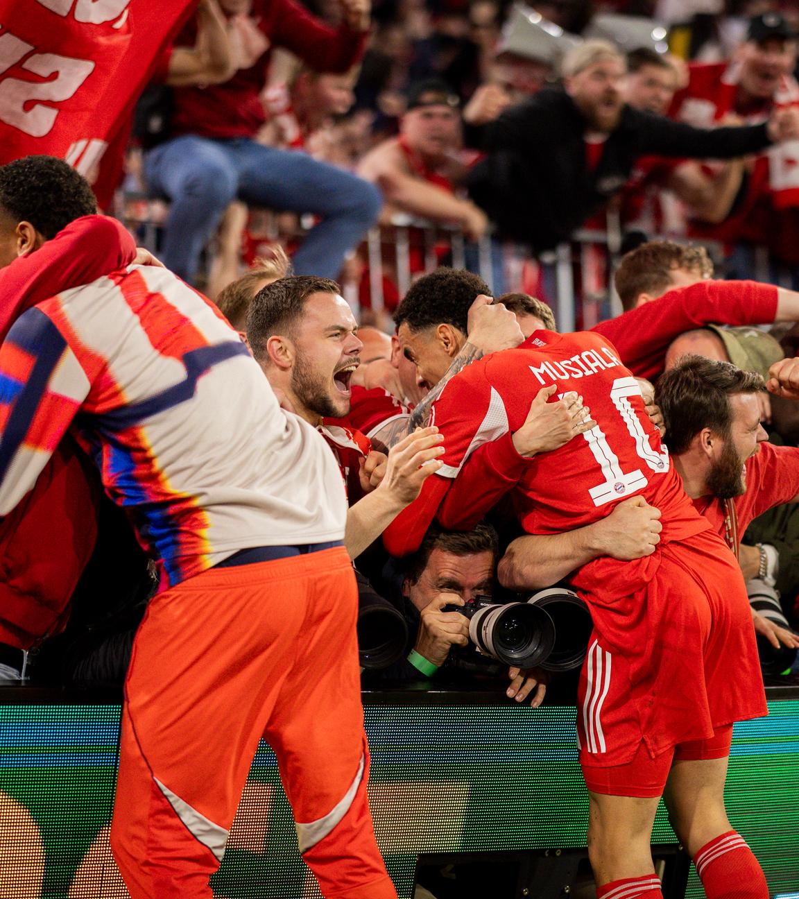 Unschöne Szenen: Bayern‑Fans überwanden nach dem letzten Treffer von Michael Olise die Absperrungen und überrannten dabei mehrere Fotografen.
