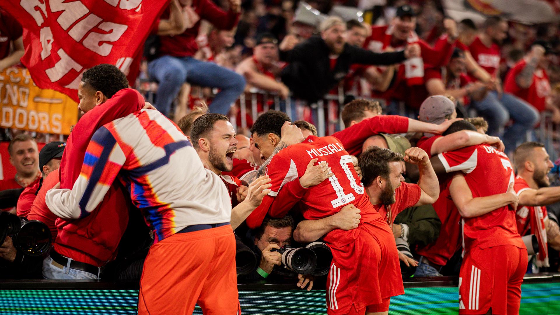 Unschöne Szenen: Bayern‑Fans überwanden nach dem letzen Treffer von Michael Olise die Absperrungen und überrannten dabei mehrere Fotografen.
