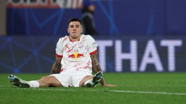 Leipzigs Benjamin Sesko sitzt enttäuscht auf dem Rasen.