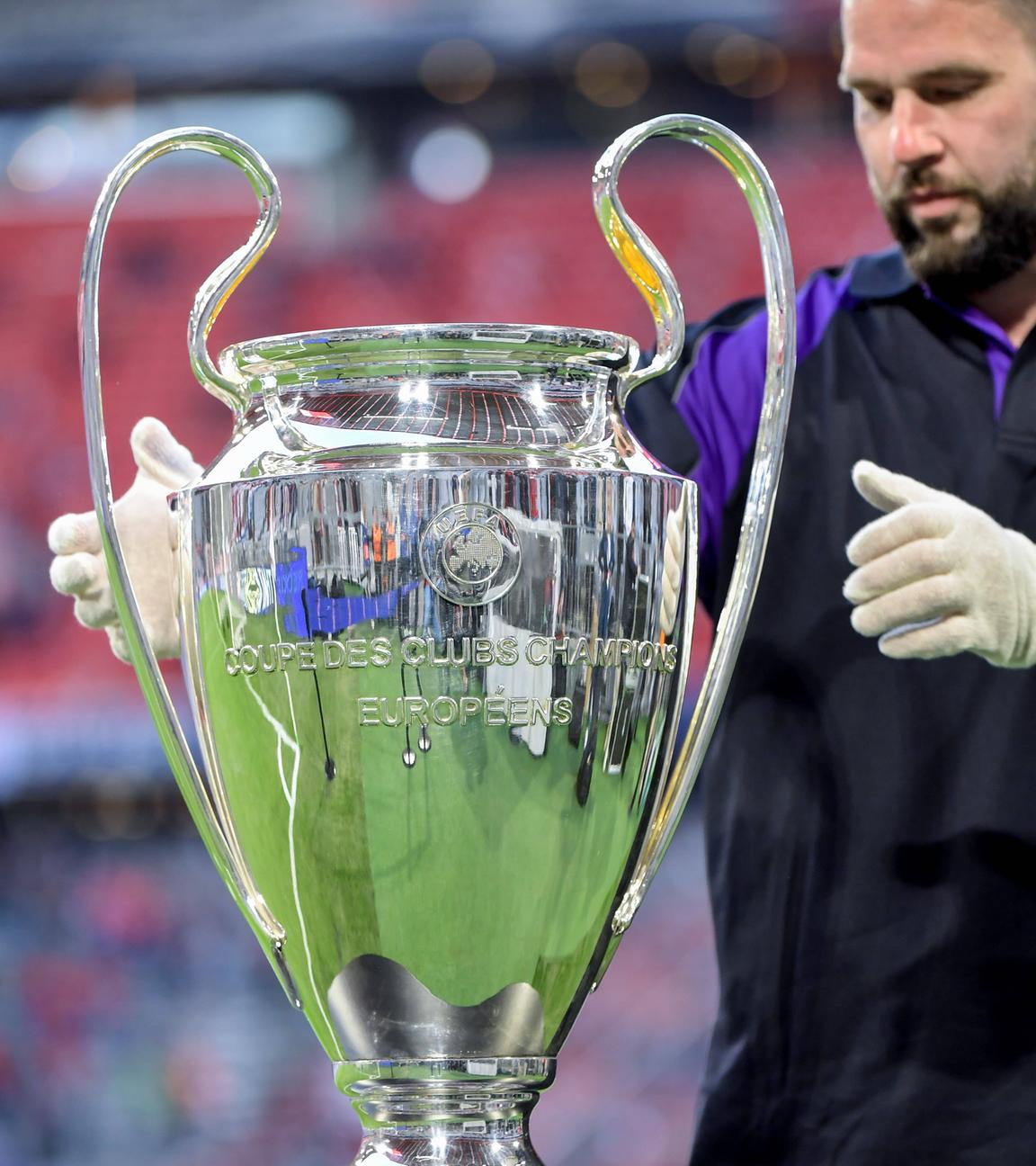 Ein Helfer platziert den Champions-League-Pokal auf einem Podest