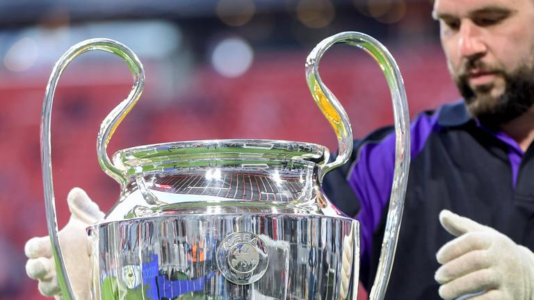 Ein Helfer platziert den Champions-League-Pokal auf einem Podest