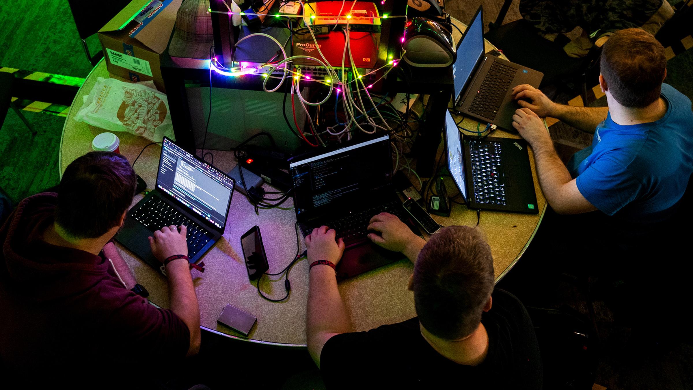 Teilnehmer des Kongresses des Chaos Computer Clubs (CCC) sitzen an einem Tisch an Computern. (Archiv)