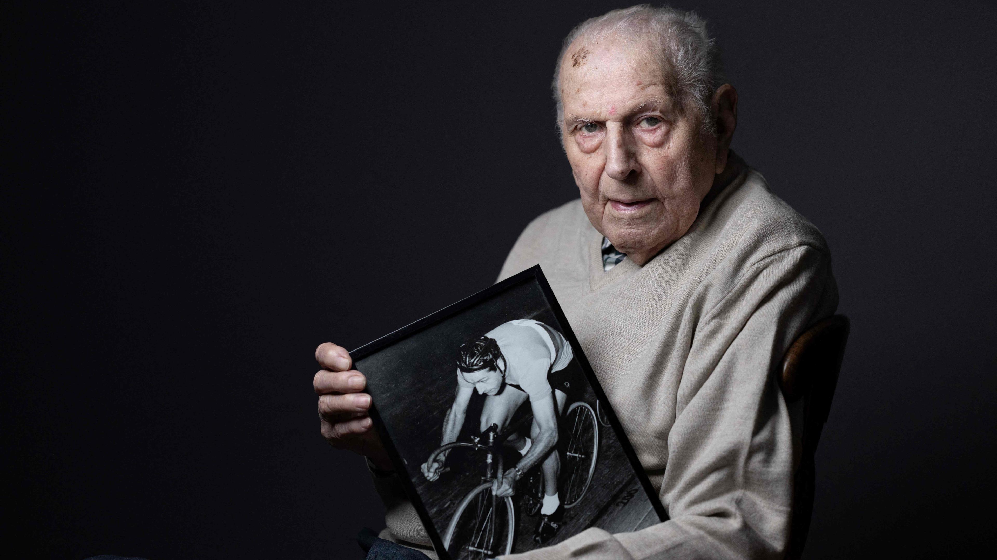 Der französische Radsportler Charles Coste posiert mit einem Foto von sich selbst