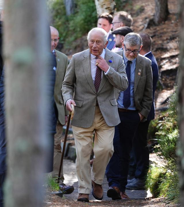 Das Bild zeigt König Charles und weitere Menschen, die durch den Nationalpark laufen.