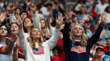 Teilnehmer heben die Hände und singen während einer Gedenkfeier für Charlie Kirk im State Farm Stadium in Glendale am 21. Sept. 2025.