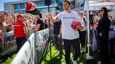 Charlie Kirk verteilt vor seiner Rede an der Utah Valley University Mützen. 