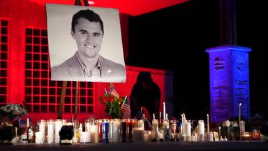 Ein Foto von Charlie Kirk steht auf einer Staffelei, darunter mehrere brennende Kerzen.