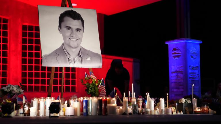 Ein Foto von Charlie Kirk steht auf einer Staffelei, darunter mehrere brennende Kerzen.