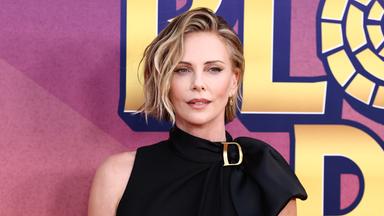 Dsa Bild zeigt Charlize Theron in einem schwarzen Kleid.