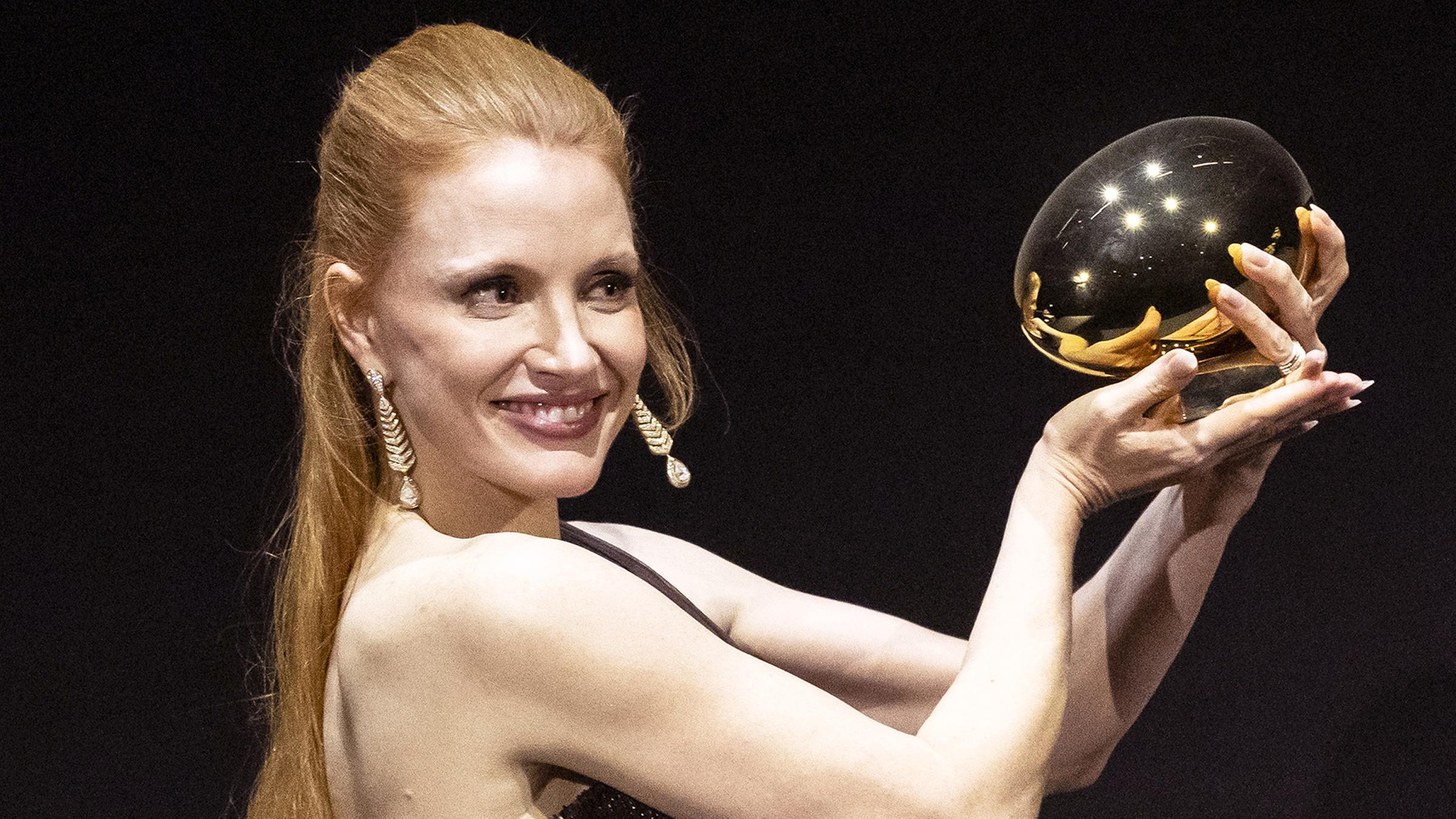 Schauspielerin Jessica Chastain hält ein goldenes Ei hoch.