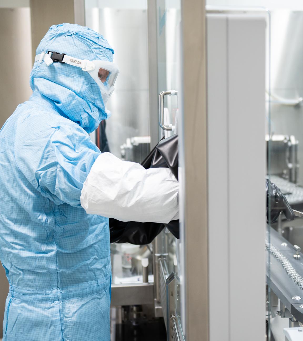 Ein Arbeiter steht an einer Abfüll- und Verschließanlage für pharmazeutische Produkte bei Takeda Pharmaceutical.