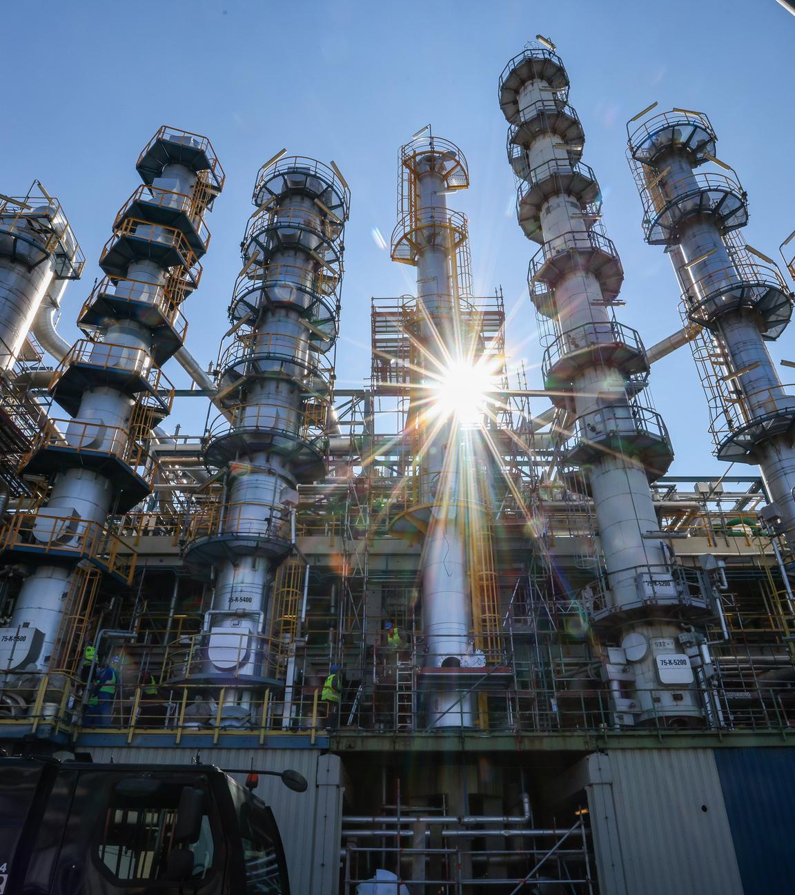 ARCHIV - 15.09.2023, Sachsen-Anhalt, Leuna: Die Sonne scheint hinter einer neuen, 26 Meter hohen Kolonne zur Phenolherstellung bei der Domo Chemicals GmbH. 