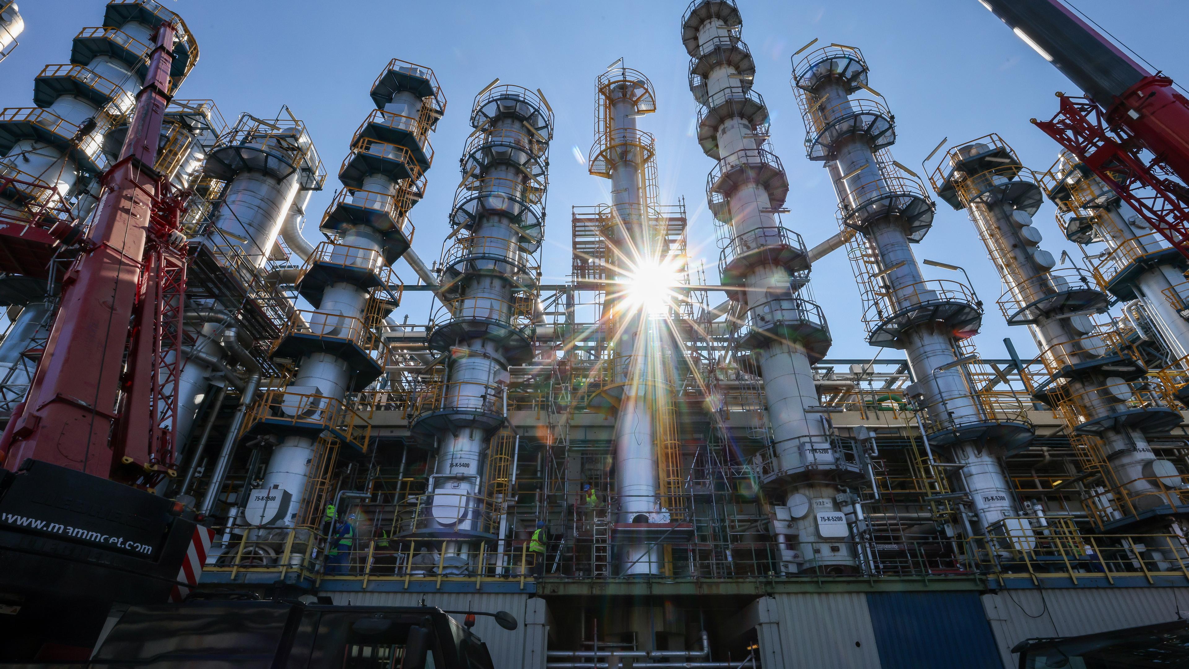 ARCHIV - 15.09.2023, Sachsen-Anhalt, Leuna: Die Sonne scheint hinter einer neuen, 26 Meter hohen Kolonne zur Phenolherstellung bei der Domo Chemicals GmbH. 