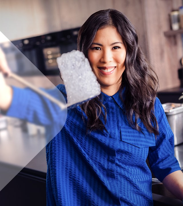 Mai Thi Nguyen-Kim in Küche blickt in die Kamera, in der Hand hält sie einen Eisblock mit Luftbläschen