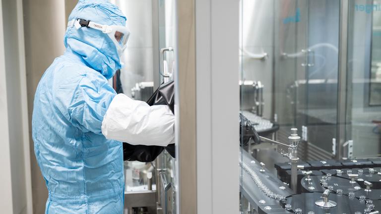 Symbolbild:  Ein Arbeiter steht an einer Abfüll- und Verschließanlage für pharmazeutische Produkte bei Takeda Pharmaceutical. 