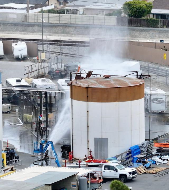 Wasser wird auf einen Tank gesprüht, der sich in einem Luft- und Raumfahrtwerk überhitzt hat. 