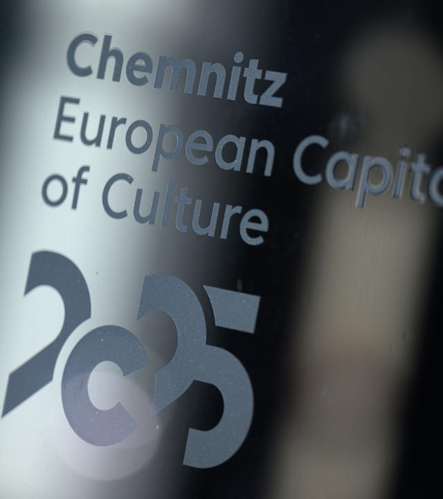 Sachsen, Chemnitz: Das Logo der Kulturhauptstadt Chemnitz 2025 (European Capital of Culture) ist an einem Fester des Welcome Centers des Kulturhauptstadtbüros zu sehen. 