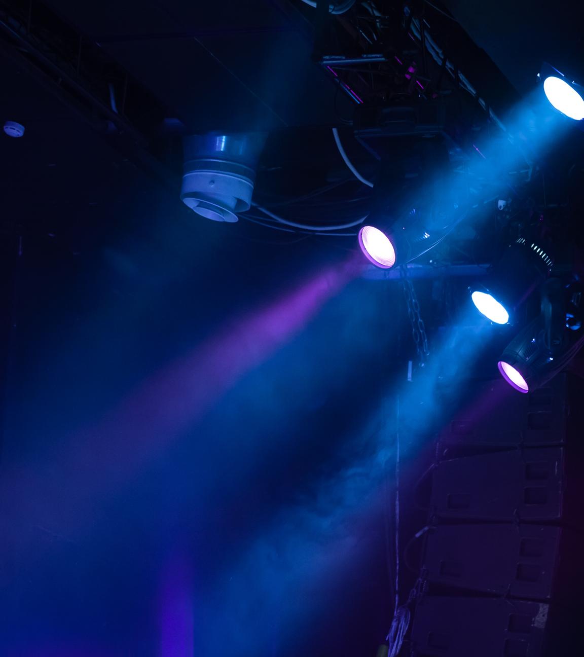 Es ist blaues Schweinwerferlicht vor schwarzem Hintergrund zu sehen.