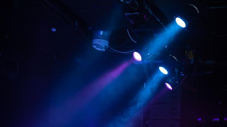 Es ist blaues Schweinwerferlicht vor schwarzem Hintergrund zu sehen.