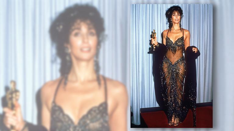 Cher in einem transparenten Outfit, hält den Oscar in der Hand 