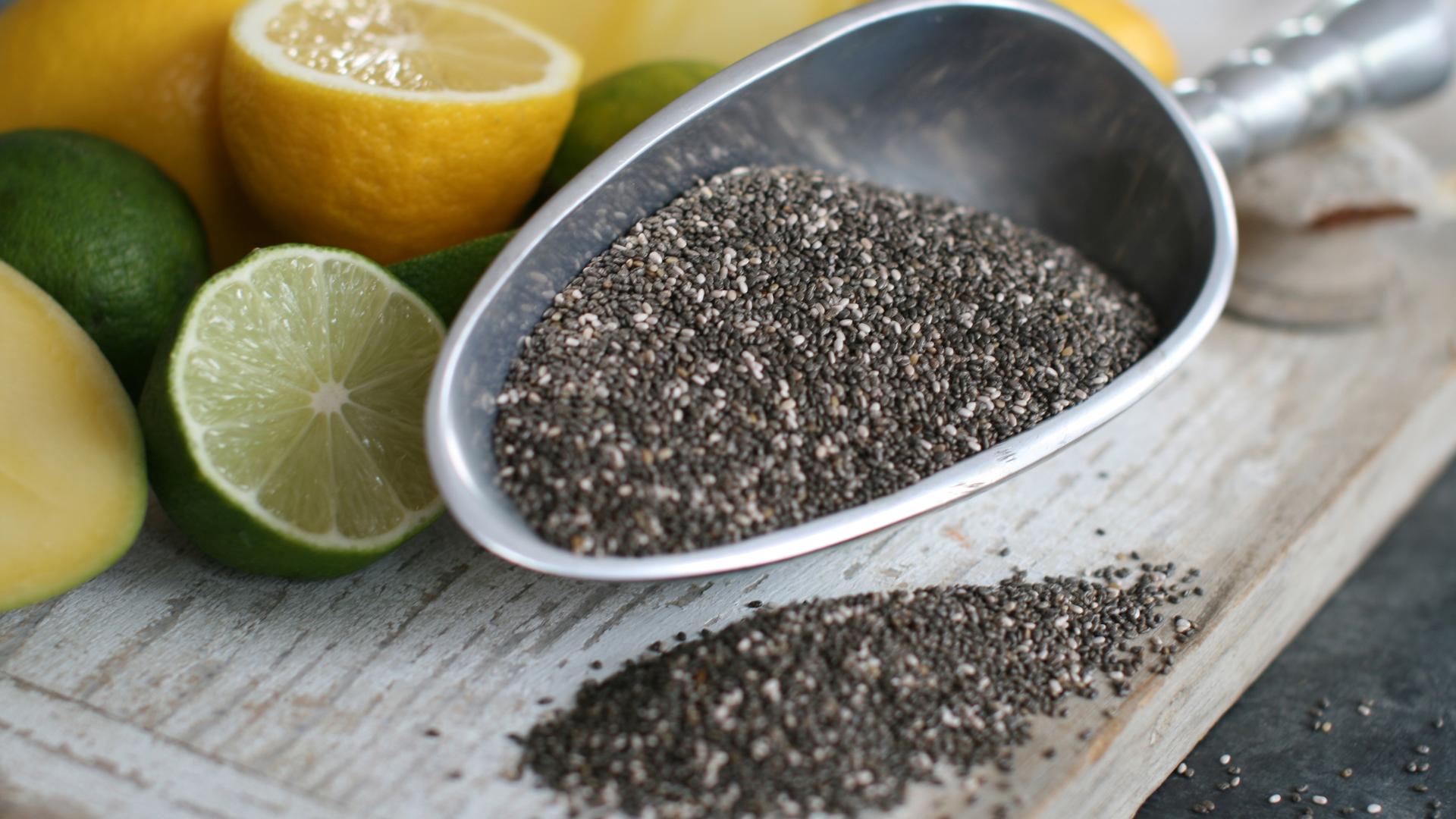 chiasamen auf einer silbernen Schippe daneben Zitronen und Limetten