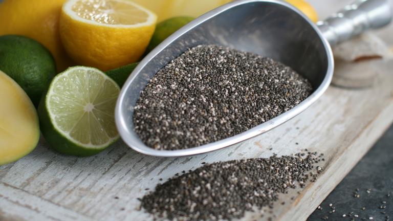 chiasamen auf einer silbernen Schippe daneben Zitronen und Limetten