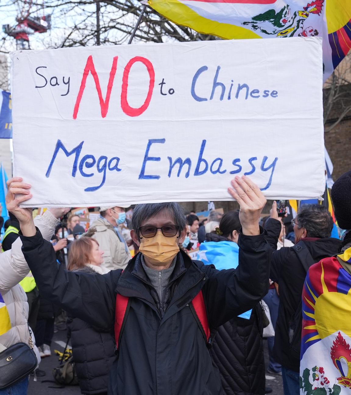 Ein:e Demonstrant:in hält ein Schild mit der Aufschrift "Say No to Chinese Mega Embassy".