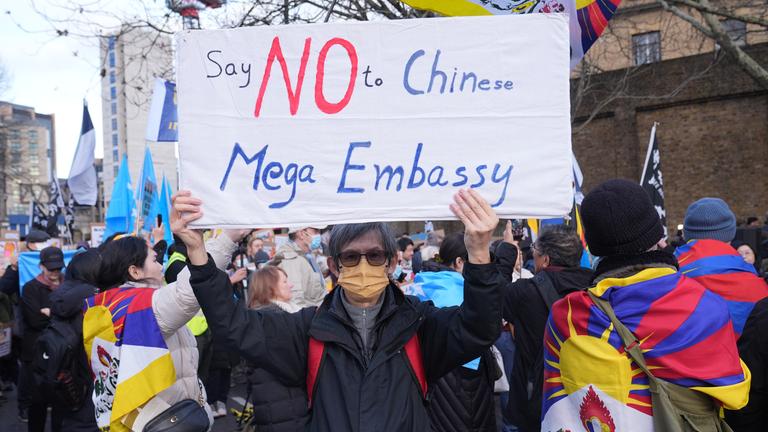 Ein:e Demonstrant:in hält ein Schild mit der Aufschrift "Say No to Chinese Mega Embassy".