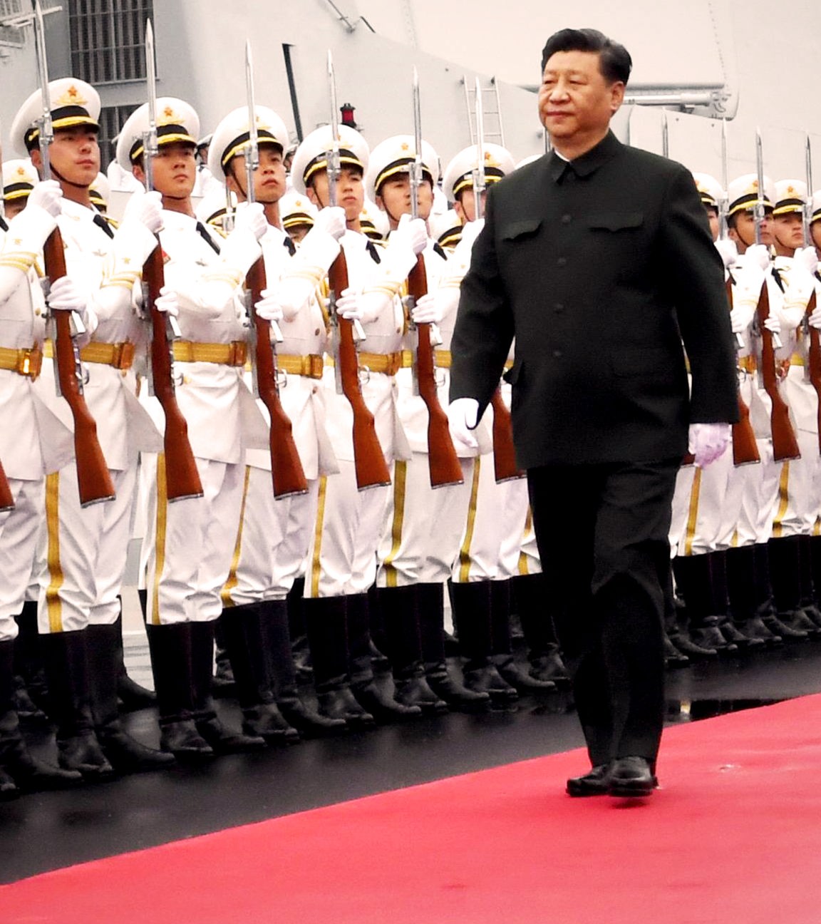 Xi Jinping läuft eine Soldatenreihe auf einem roten Teppich ab.