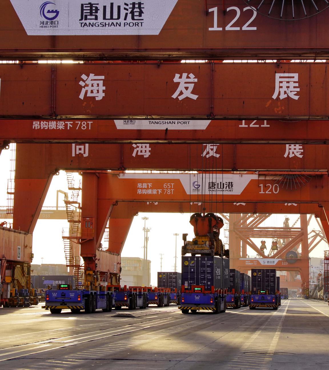  Unbemannte Fahrzeuge fahren unter Containerbrücken am Containerterminal des Hafens von Tangshan in der nordchinesischen Provinz Hebei.