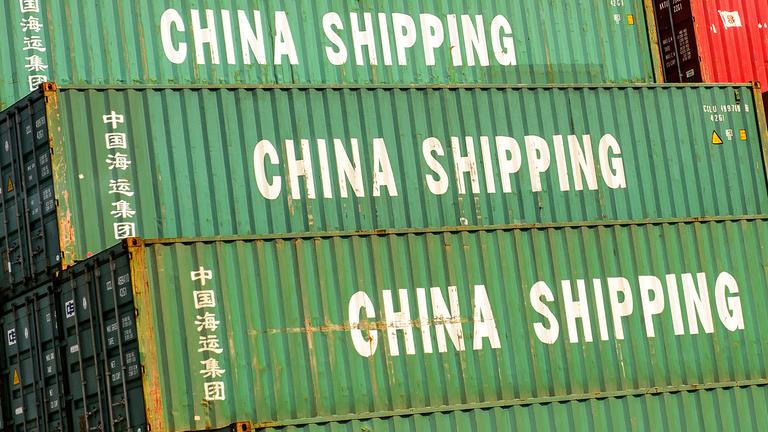 Container mit der Aufschrift "China Shipping" stehen im Hafen. 