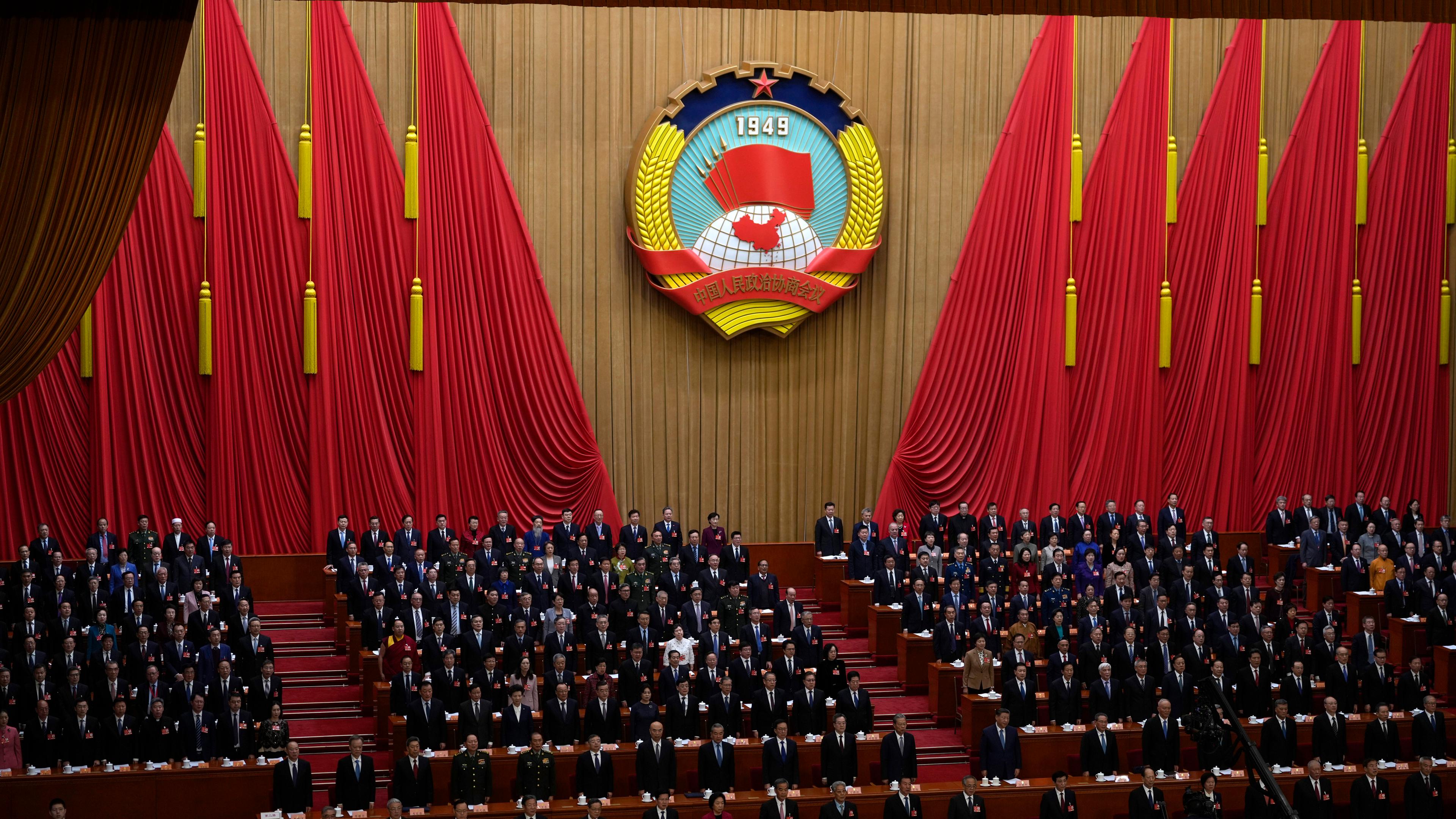 Vor dem Nationalen Volkskongress 2025 in China stehen chinesische Regierungsvertreter bei der Eröffnung der Politischen Konsultativkonferenz des Chinesischen Volkes in der Großen Halle des Volkes für die Nationalhymne auf.