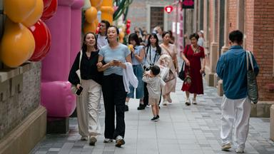 Mehrere Menschen laufen auf einer Straße in Shanghai.