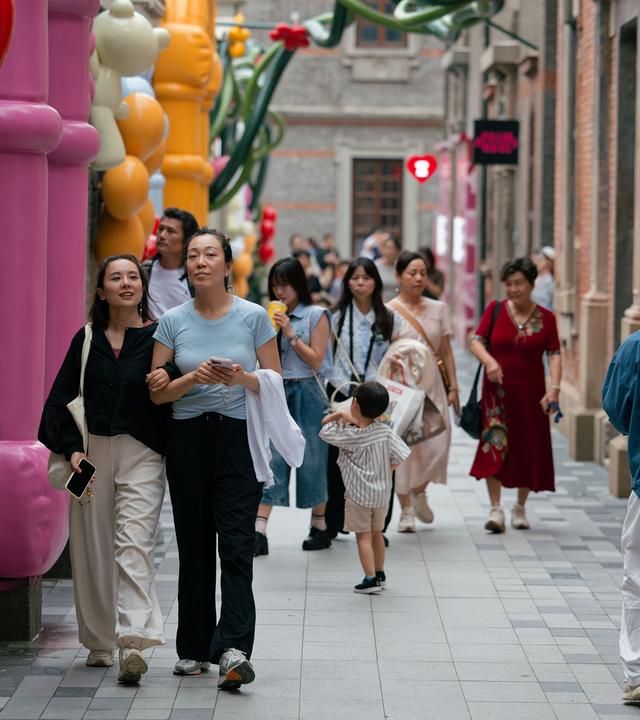 Mehrere Menschen laufen auf einer Straße in Shanghai.