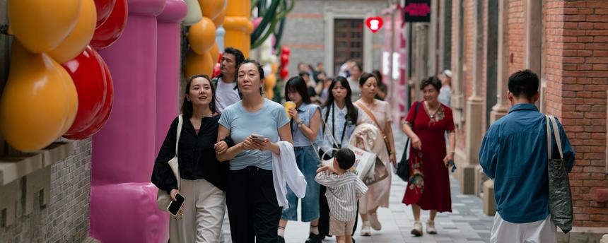 Mehrere Menschen laufen auf einer Straße in Shanghai.