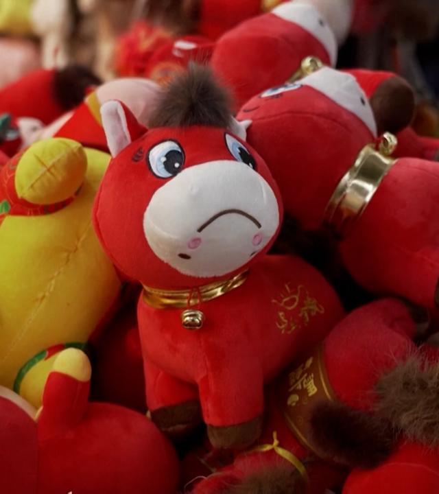 Viele Stofftiere, die meisten rot. Im Zentrum des Bildes ein traurig schauendes rotes Stoffpferd.