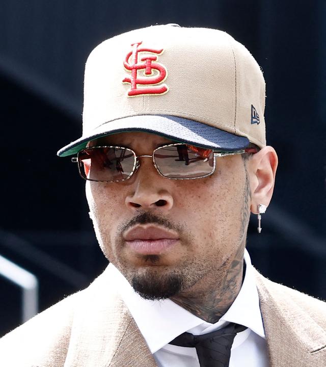 Auf dem Bild ist zu sehen: Nahaufnahme von Chris Brown. Er trägt eine cremefarbene Baseballkappe und eine Sonnenbrille.
