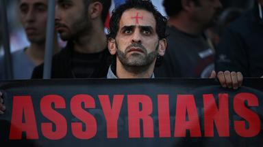 Ein assyrischer Mann mit einem Roten Kreuz auf der Stirn ein Banner, während er in der Innenstadt von Beirut gegen Christenverfolgung protestiert, aufgenommen am 28.02.2015 