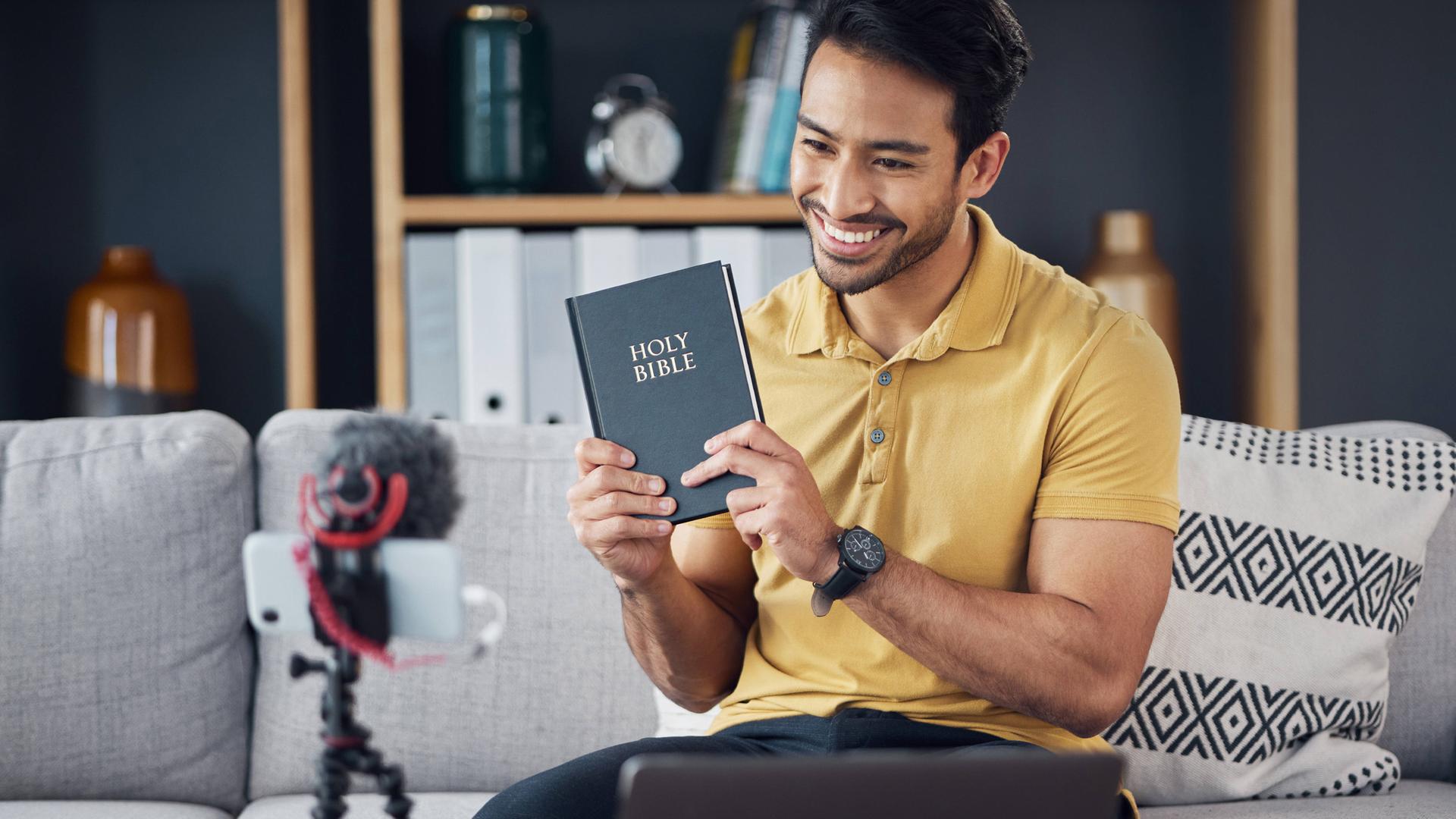Symbolbild eines Influencers mit einer Bibel.